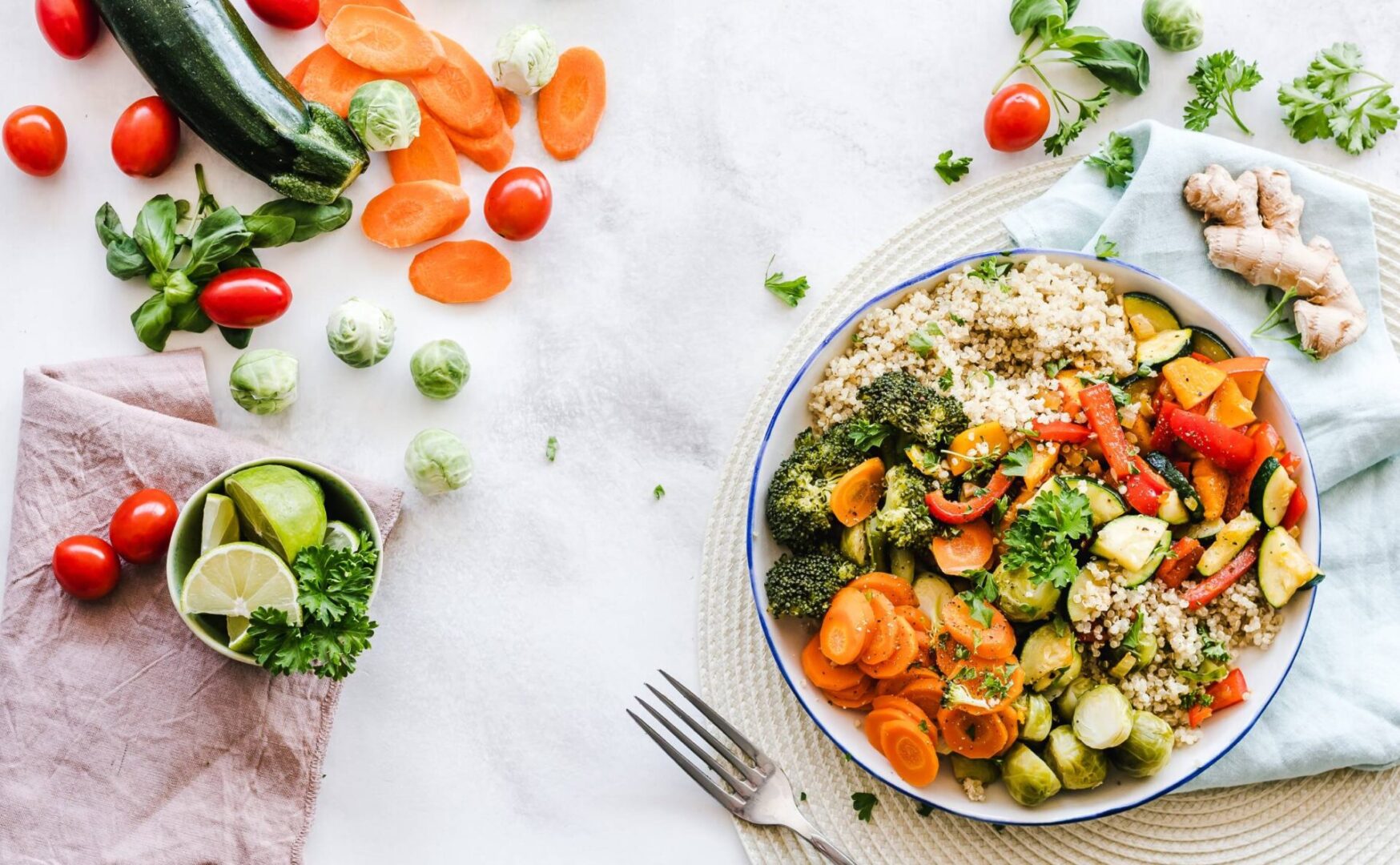 A colorful bowl of quinoa with steamed vegetables and fresh herbs.