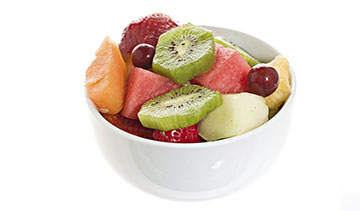A bowl of fresh mixed fruit including kiwi, grapes, watermelon, and melon.