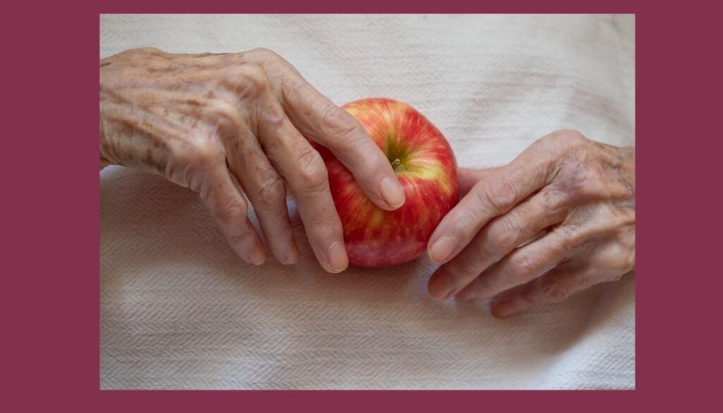 Elderly hands holding an apple